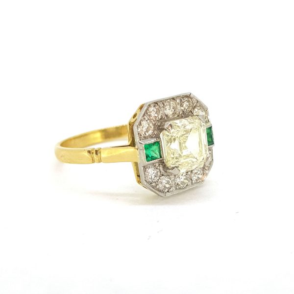 1.70ct Asscher Cut Diamond Cluster Dress Ring with Emeralds; central 1.70 carat Asscher-cut diamond surrounded by 0.40cts brilliant-cut diamonds with square emeralds to the sides