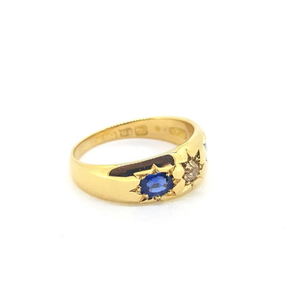 Antique Victorian Sapphire and Diamond Three Stone Ring; central diamond flanked by sapphires, each in star shaped cut down settings in 18ct yellow gold