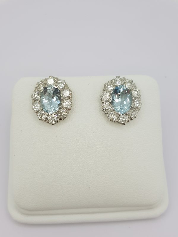 Aquamarine and Diamond Oval Cluster Stud Earrings; featuring 2.50cts oval facetted aquamarines within 1.90ct diamond surrounds, in 18ct white gold