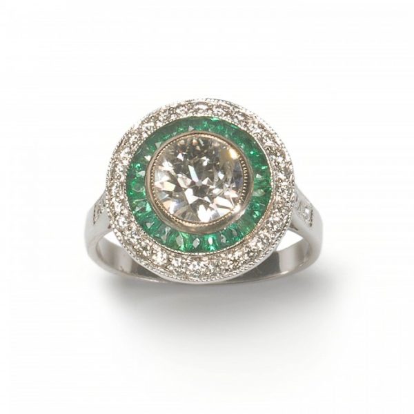 Art Deco Style 1.29ct Diamond and Emerald Target Cluster Ring; central 1.29ct round European old-cut diamond surrounded by French-cut emeralds and an outer border of brilliant-cut diamonds, with diamond-set shoulders, in platinum