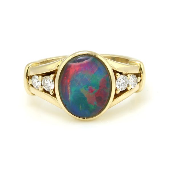 Vintage Black Opal and Diamond Ring by Charles Greig; central 2.30ct oval cabochon black opal with two diamond accents to each side, in 18ct yellow gold, Circa 1990s