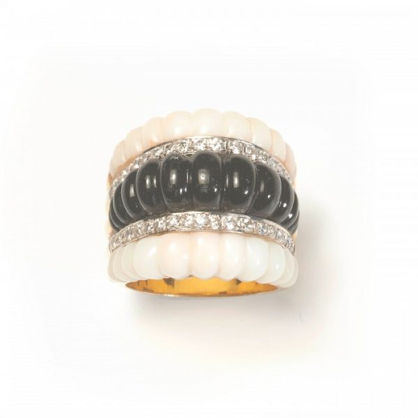 Vintage Coral, Black Onyx and Diamond Ring, central row of carved ribbed black onyx flanked by diamond-set rows and ribbed carved angel skin coral to the outer edges, in 14ct yellow gold, Circa 1980