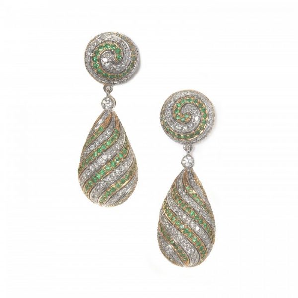 Contemporary Emerald and Diamond Swirl Drop Earrings; round swirl tops and pendant drops set with round brilliant-cut diamonds in 18ct white gold swirling rows alternating with round faceted emeralds in 18ct yellow gold
