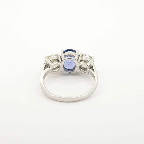 Natural Sapphire and Diamond Three Stone Ring; central 2.52 carat natural oval blue sapphire flanked by 2cts cushion-shaped diamonds, in 18ct white gold