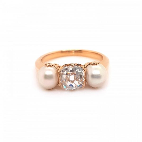 Antique Victorian Natural Pearl and Old Cut Diamond Three Stone Ring; central 1.45ct cushion-shaped old-cut diamond flanked by natural pearls, in 18ct yellow gold with fleur-de-lis claws, Circa 1890
