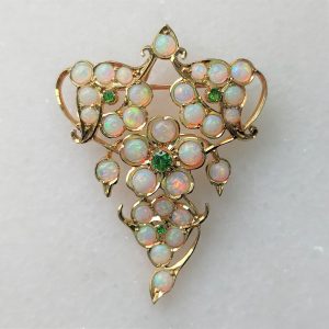 A beautiful antique opal and demantoid garnet brooch~pendant set throughout with precious opals that display a rainbow of colours from the turn of the last century.