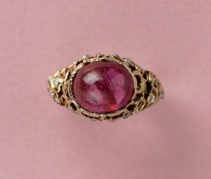 Decorative 4.7ct Burma Pink Sapphire and Diamond Ring, Certified 4.70 carat cabochon-cut natural unenhanced red-pinkish Burma sapphire set high on an 18ct yellow gold scrolled openwork shank decorated with rose cut diamonds