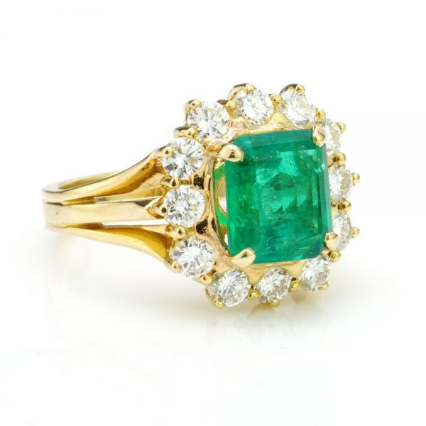 3.80ct Emerald Cut Emerald and Diamond Cluster Ring, in 18ct yellow gold with triple-split shoulders