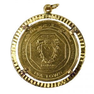 24ct Gold Bahrain 10 Dinars Coin in 18ct Gold Charm Pendant; 18ct yellow gold coin holder containing a 24ct gold Bahrain 10 Dinars Isa Town coin. This rare coin was produced by the British Royal Mint in 1968 on behalf of the Middle Eastern country to mark the creation of Isa Town.