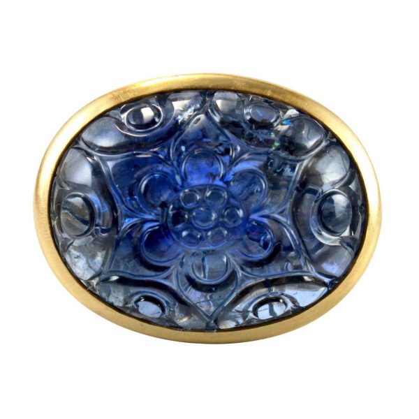 Large Carved Floral Mughal Sapphire Ring; 18th century natural sapphire of approximately 45-50 carats beautifully carved with a Mughal floral motif and set into a later 20th century contemporary 18ct yellow gold mount and shank