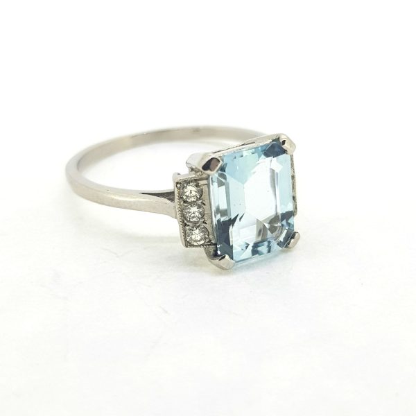 Aquamarine and Diamond Dress Ring, central 2ct emerald-cut aquamarine flanked either side by a row of three diamonds, in 18ct white gold