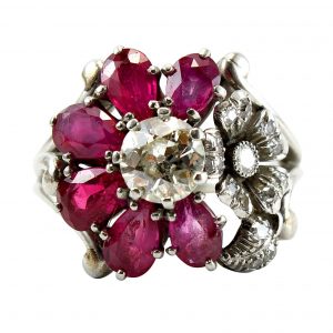 Vintage 1940s Ruby and Diamond Flower Cluster Ring; central 0.85ct old European-cut diamond surrounded by six pear-cut ruby petals with another diamond studded flower