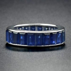 Baguette Sapphire Full Eternity Ring in 18ct Gold; set with twenty-two vertically channel-set baguette-cut sapphires totalling 14.3 carats. Made to order