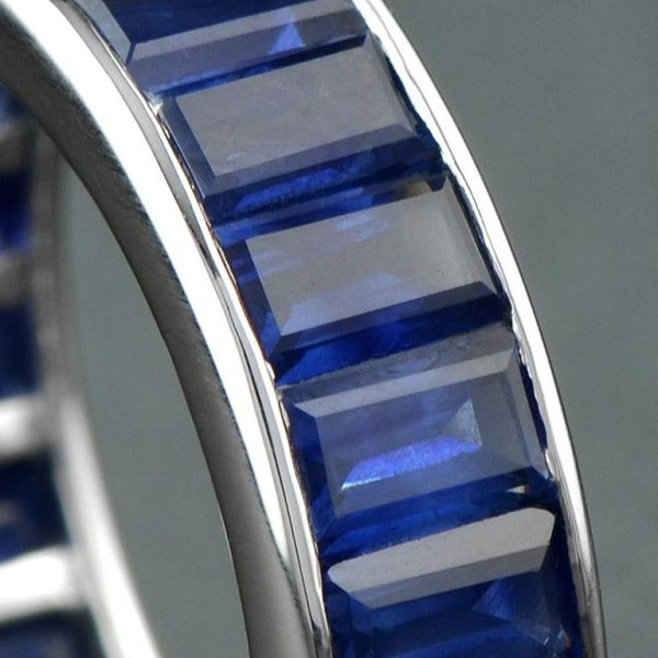 Baguette Sapphire Full Eternity Ring in 18ct Gold; set with twenty-two vertically channel-set baguette-cut sapphires totalling 14.3 carats. Made to order