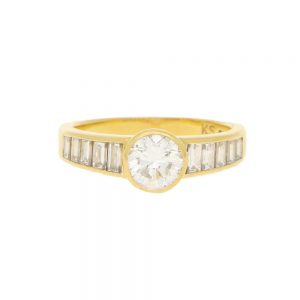 Contemporary 1ct Diamond Ring with Baguette Shoulders; central collet-set 1ct round brilliant-cut diamond flanked to each side by 1ct graduated baguette-cut diamonds in 18ct yellow gold