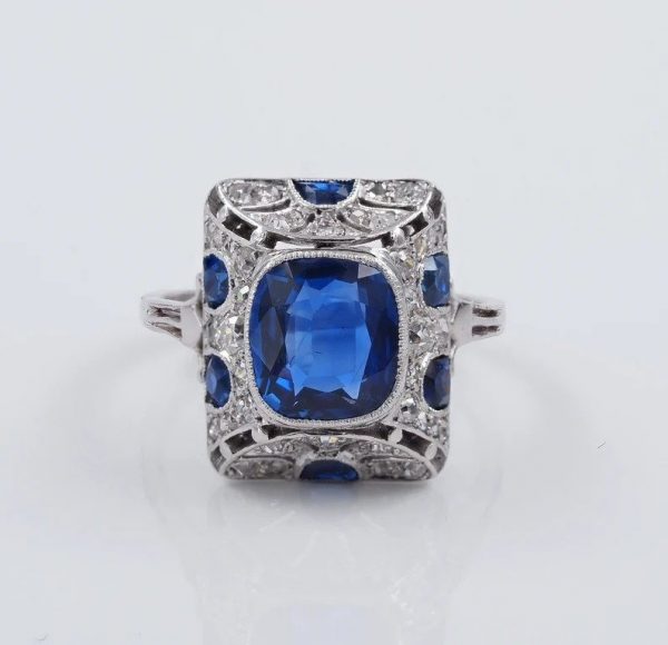 Art Deco French Burma Sapphire and Diamond Cocktail Ring in Platinum; central certified natural no heat 2.81ct cushion-cut Burmese sapphire within pierced platinum frame decorated with 1.10cts old mine-cut and rose-cut diamonds with 0.60cts calibre sapphire accents. Made in France, Circa 1920