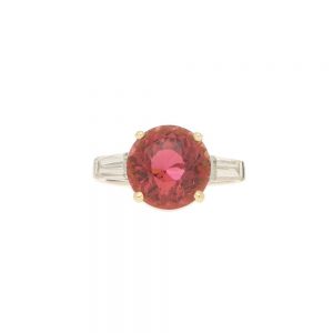 Pink Tourmaline and Diamond Engagement Ring; round faceted pink tourmaline four-claw set and flanked by two tapered baguette cut diamonds to the shoulders