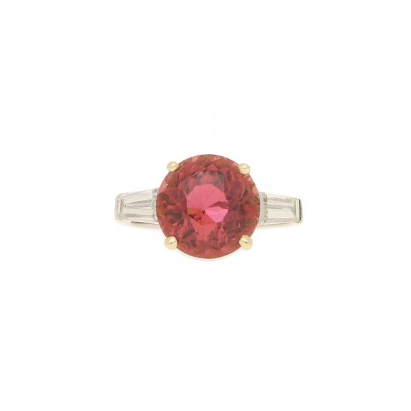 Pink Tourmaline and Diamond Engagement Ring; round faceted pink tourmaline four-claw set and flanked by two tapered baguette cut diamonds to the shoulders