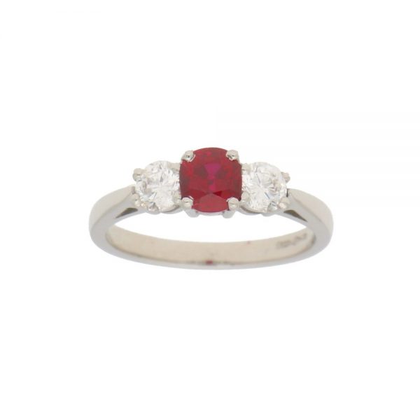 0.98ct Ruby and Diamond Trilogy Engagement Ring; central 0.98ct cushion-cut ruby flanked by 0.62cts brilliant-cut diamonds in 18ct white gold