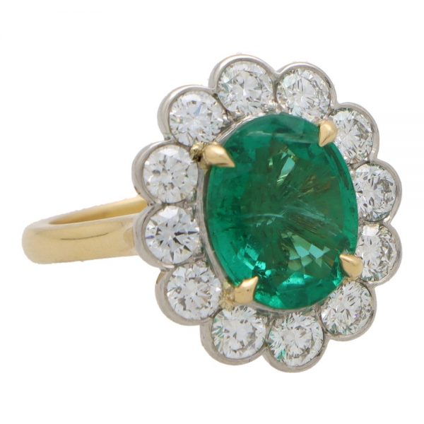 Large emerald and diamond cluster ring
