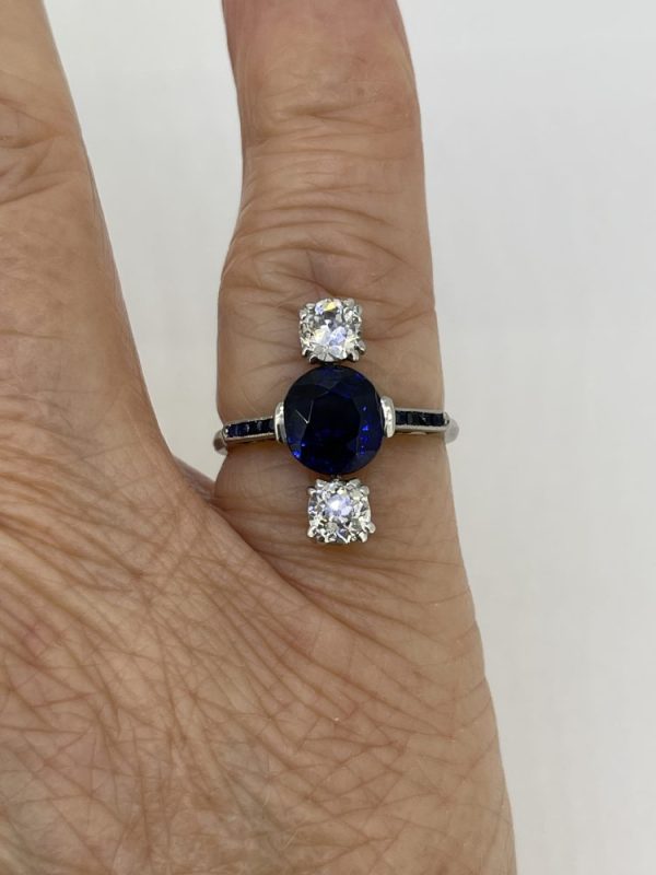 Natural Sapphire and Old Cut Diamond Trilogy Ring, faceted old cut sapphire flanked top and bottom by old-cut diamonds set vertically with sapphire set shoulders in platinum