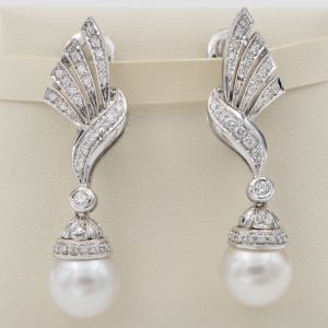 Glamorous Vintage Pearl and Diamond Spray Drop Earrings, diamond-set bow and spray designs suspending pearl drops in 18ct white gold. Circa 1960s