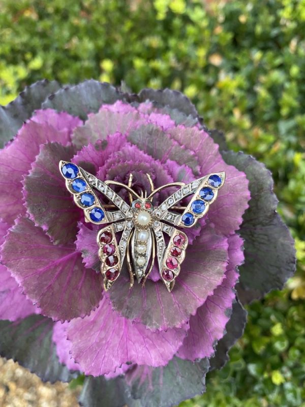 Victorian Antique Pearl Ruby Sapphire and Diamond Butterfly Brooch, with rose-cut diamond set wings edged with rubies and sapphires and a body of pearls