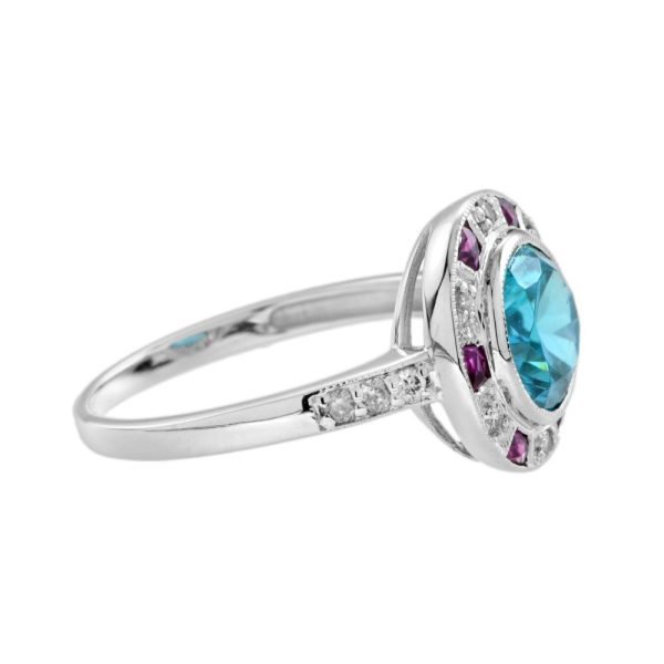 2.75ct Blue Zircon Ring with Ruby and Diamond Halo Cluster, central round-cut blue zircon is surrounded by rubies with a deep pink hue and diamonds with diamond-set shoulders in 14ct white gold