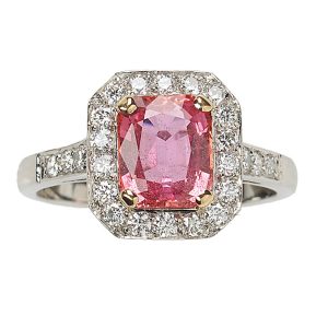 Octagonal radiant cut Padparadscha sapphire and diamond cluster ring mounted in platinum.