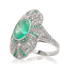 Oval cut emerald ring surround by emeralds and diamonds set in platinum.