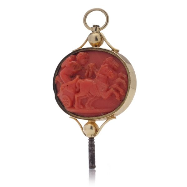 Victorian pocket watch key/pendant in gold and carved coral showing neoclassical scenes.