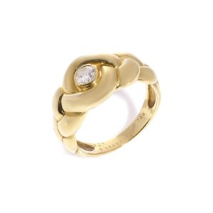 Van Cleef & Arpels gold ring with a diamond at it's heart.