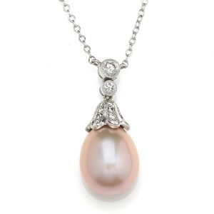 Pink pearl drop pendant in white gold with diamond set articulated top and cap with mille grain decoration.