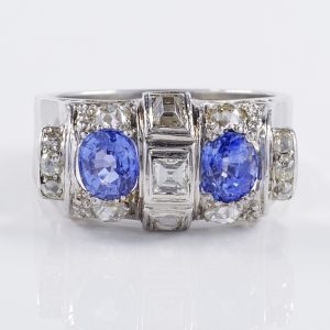 Art Deco 1.60ct Ceylon Sapphire and Old Cut Diamond Two Stone Tank Ring, two Ceylon sapphires with beautiful cornflower blue hue surrounded by old mine-cut diamonds with central raised section of square and rectangular step-cut diamonds in platinum. Circa 1925