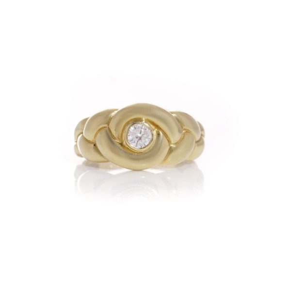 Van Cleef & Arpels gold ring with a diamond at it's heart.