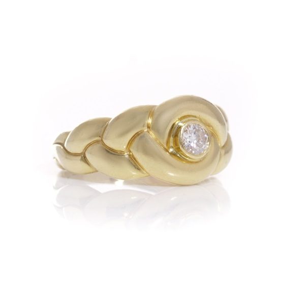 Van Cleef & Arpels gold ring with a diamond at it's heart.