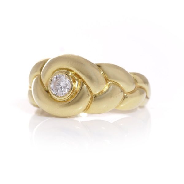 Van Cleef & Arpels gold ring with a diamond at it's heart.