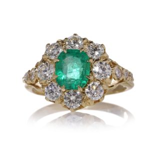 Emerald and diamond cluster ring in gold.