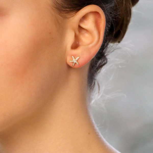 Modern diamond starfish stud earrings set in yellow gold.