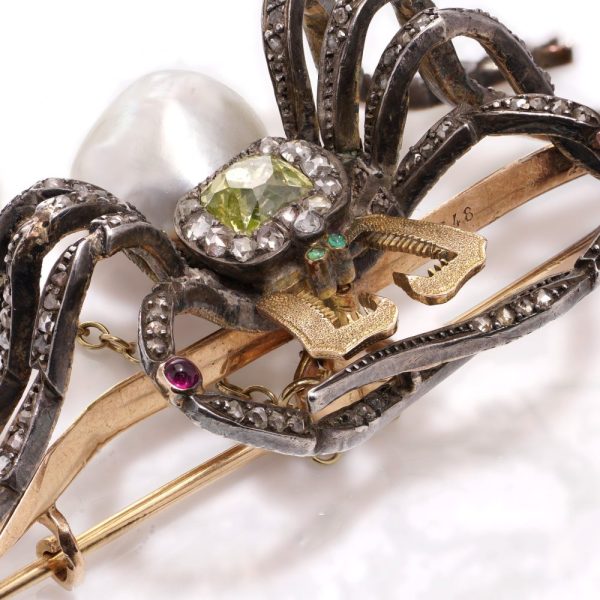Antique spider brooch with diamonds, pearl, rubies and emeralds in gold and silver.