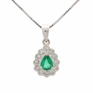 Emerald and diamond cluster pendant in white gold.