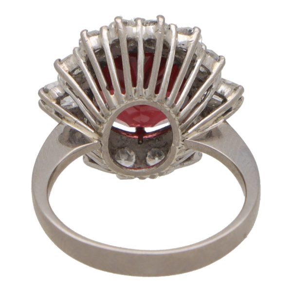 Garnet and diamond halo ring set in platinum.