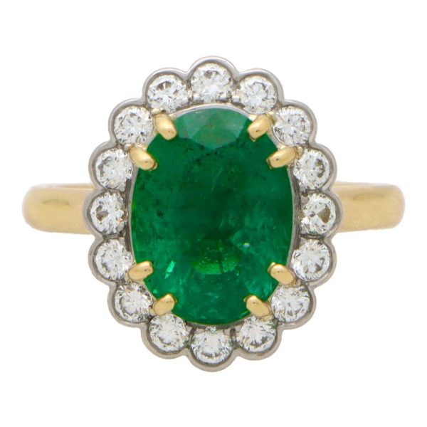 Emerald and diamond cluster ring in gold and platinum.