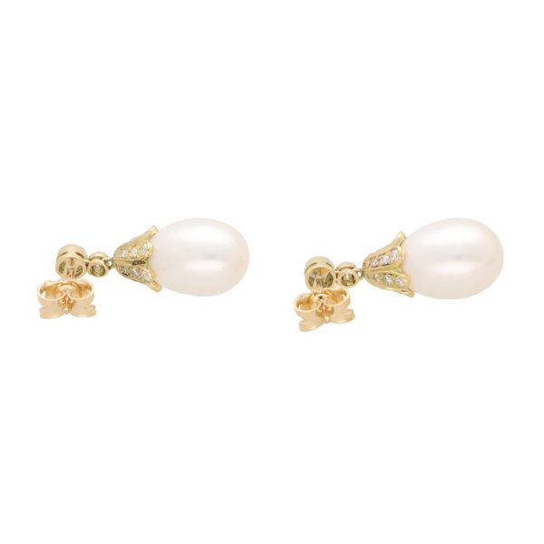 Pearl and diamond drop earrings in yellow gold.