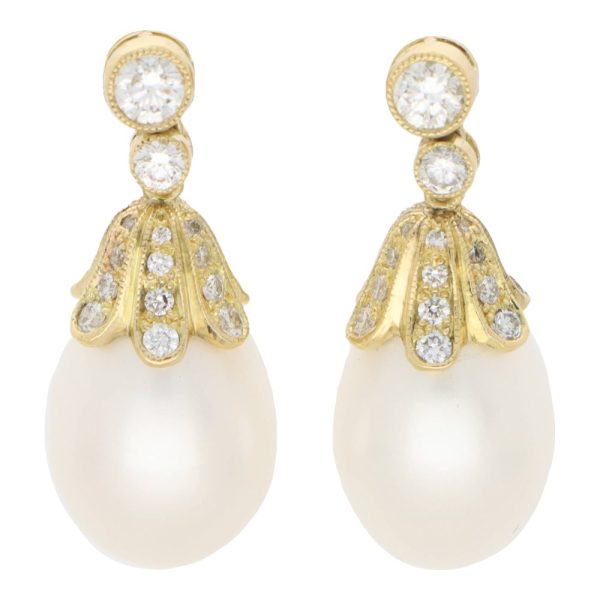 Pearl and diamond drop earrings in yellow gold.