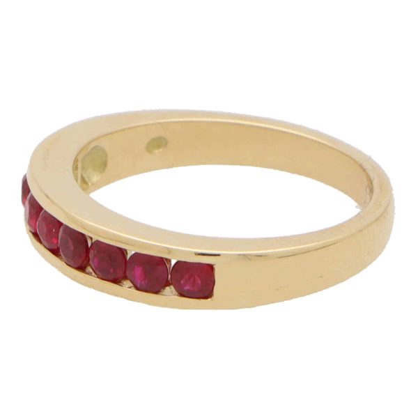 Ruby half eternity ring set in 18 carat yellow gold.