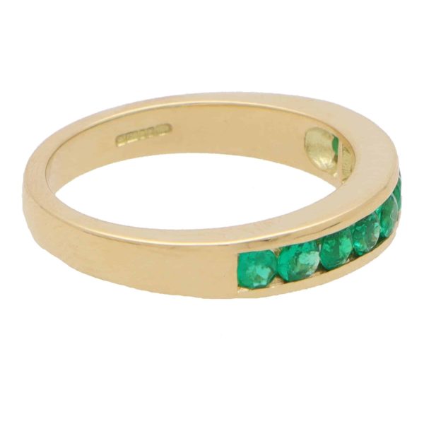 Emerald half eternity ring set in yellow gold.