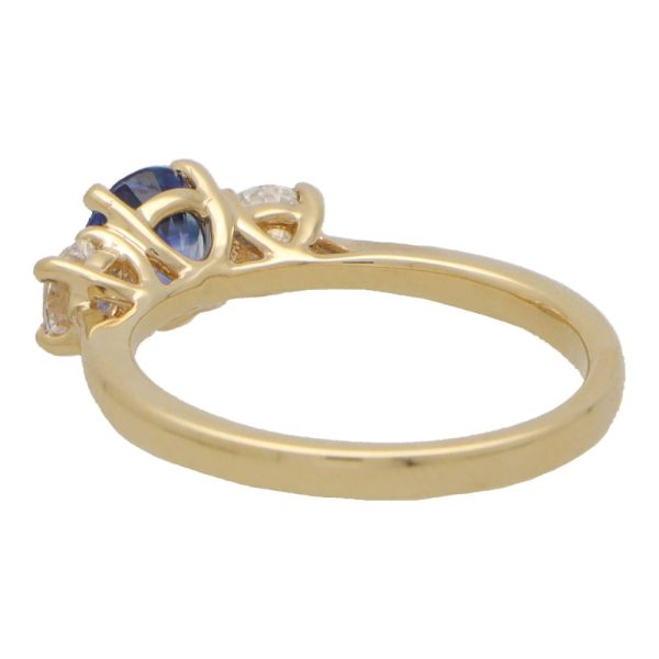 Diamond and sapphire three stone ring in yellow gold.