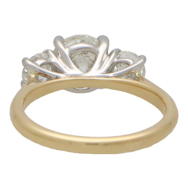 Diamond three stone engagement ring in yellow and white gold.