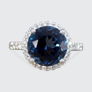 Halo cluster ring with London blue topaz and diamonds set in platinum.
